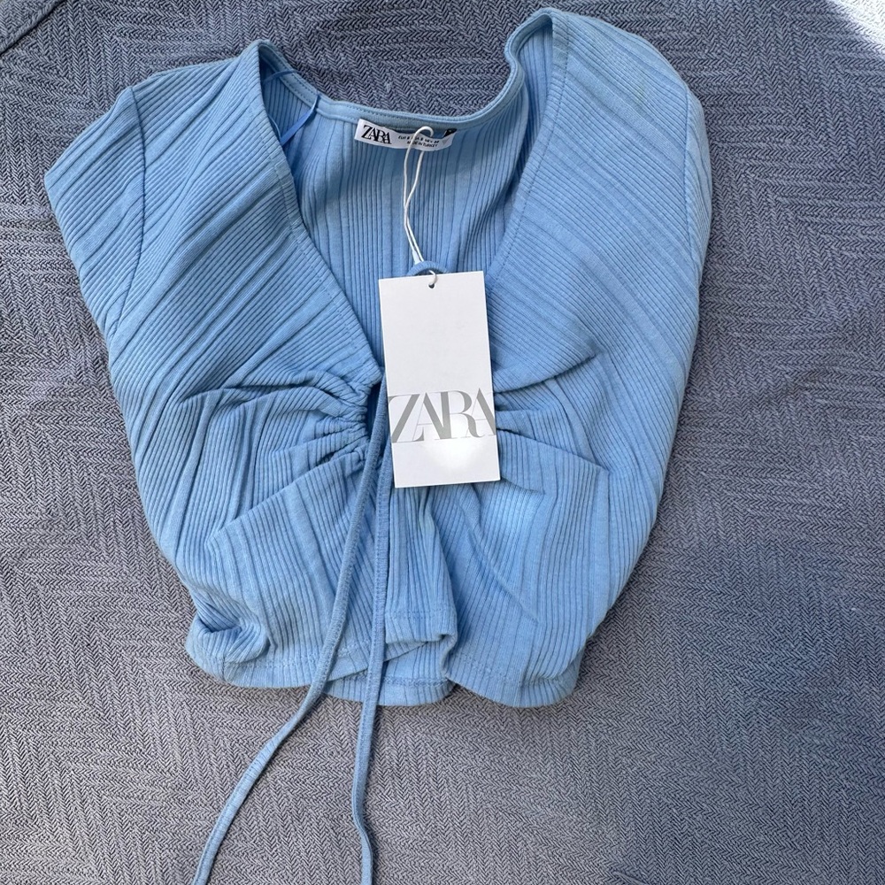 Blue ribbed crop top. With hole cut out.